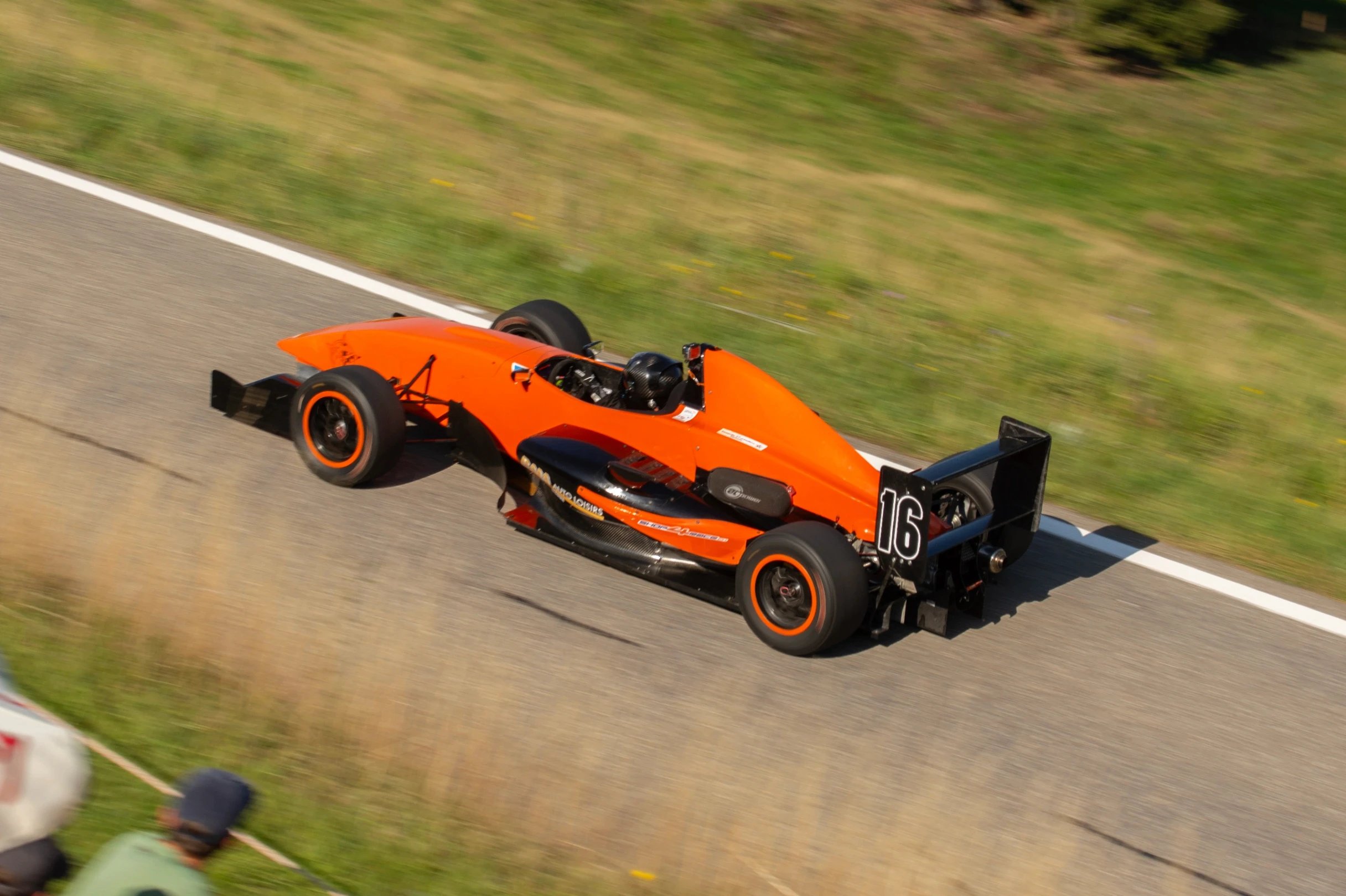 Orange race car with number 16 on the track
