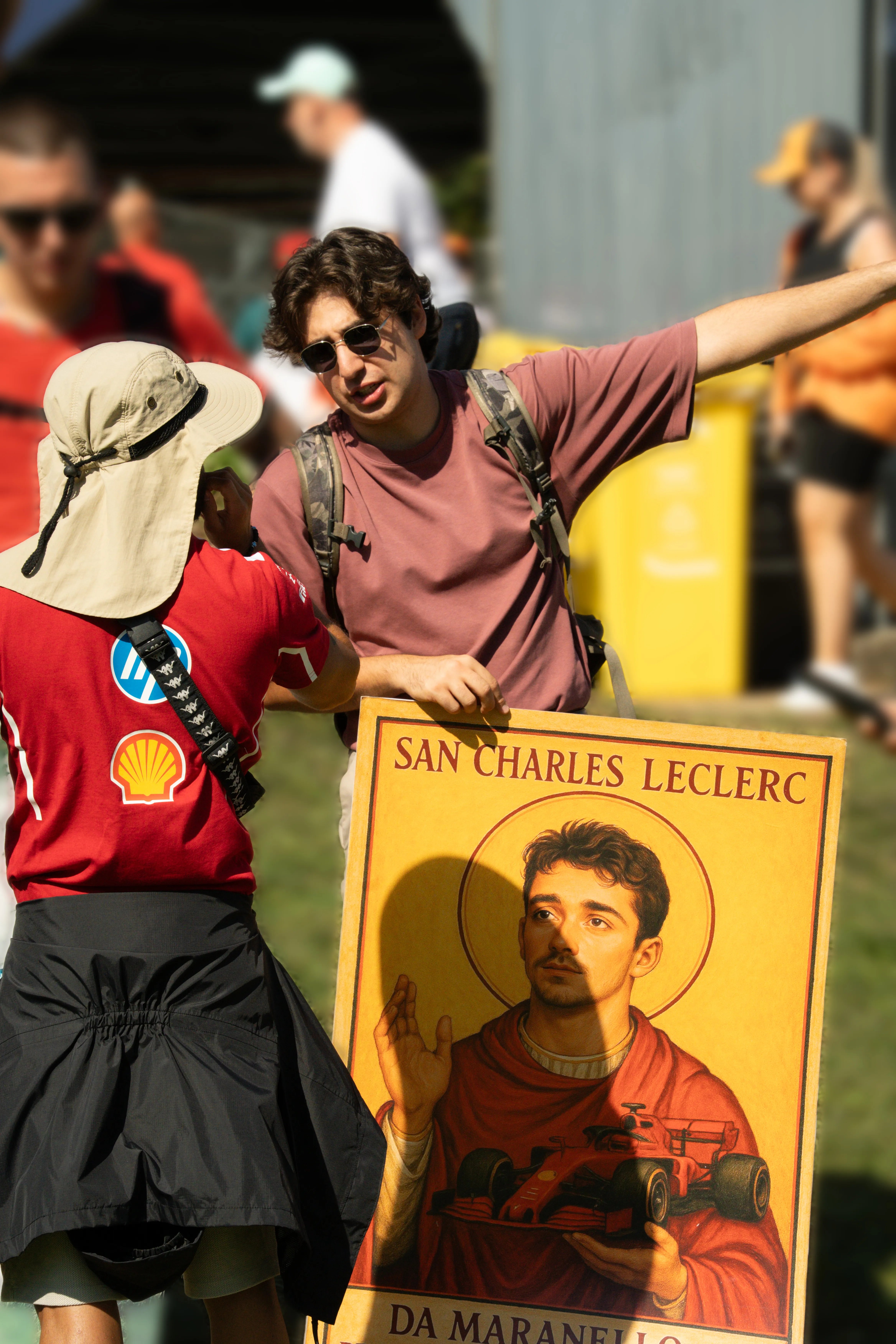 Fan holding a painting of Charles Leclerc with a race car.