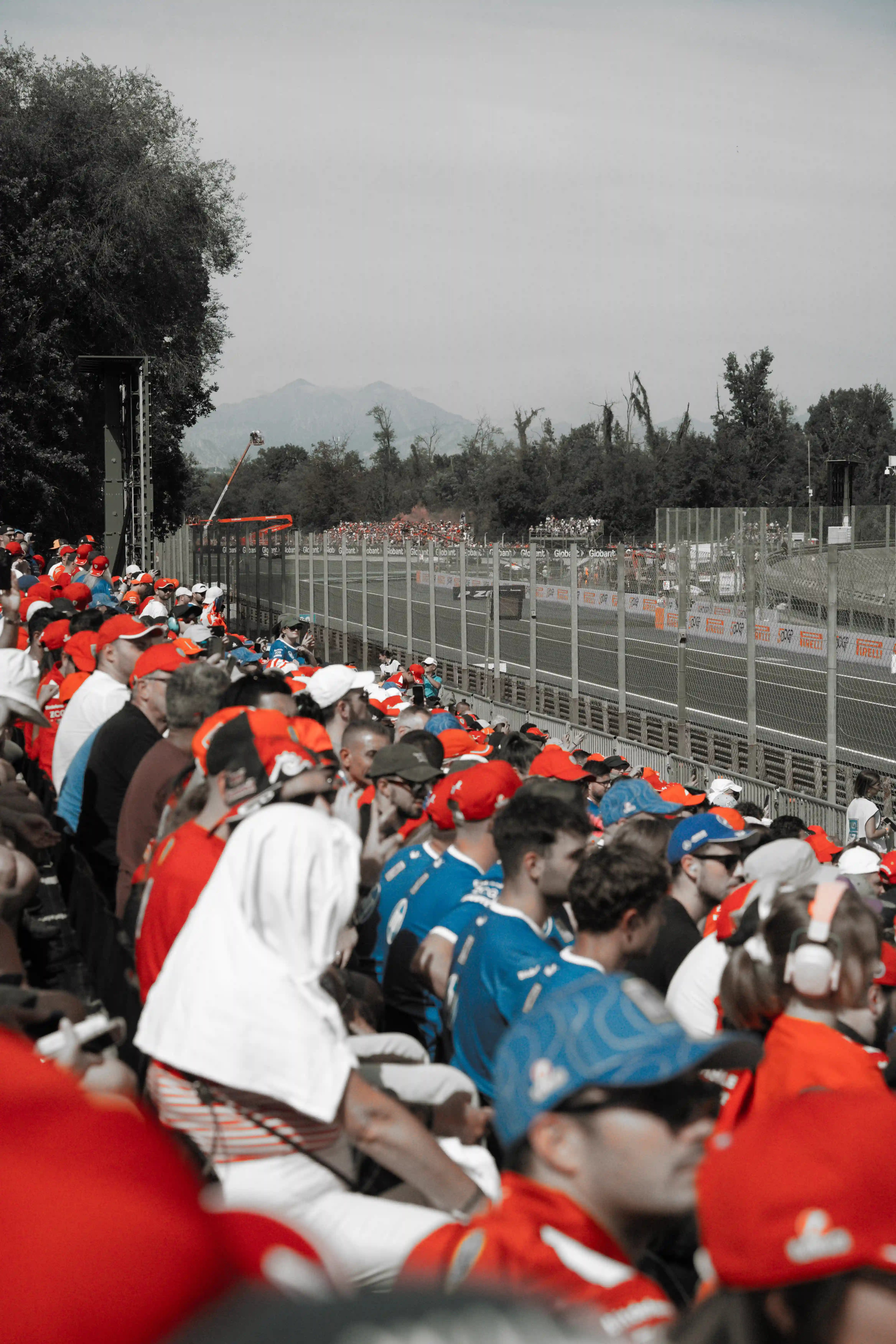 Crowd at Autodromo di Monza track with f1 cars in the background.