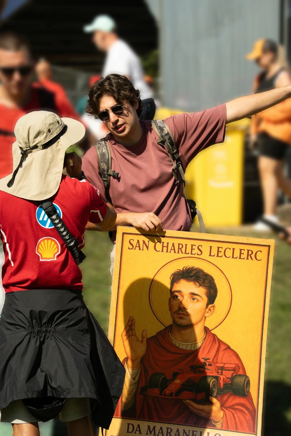 Fan holding a Charles Leclerc poster with stylized halo