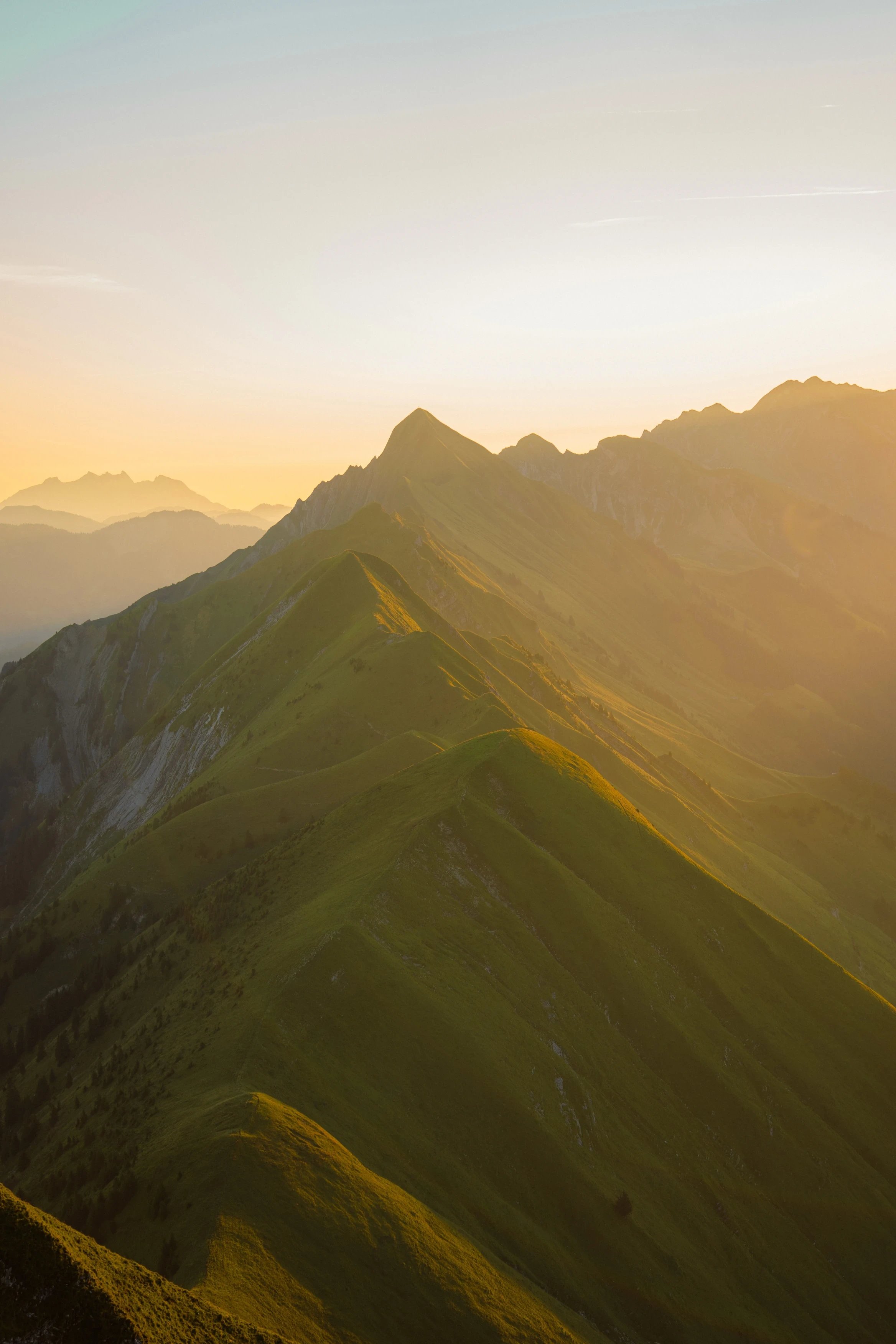Sunlit mountain ridges under a gradient sky.